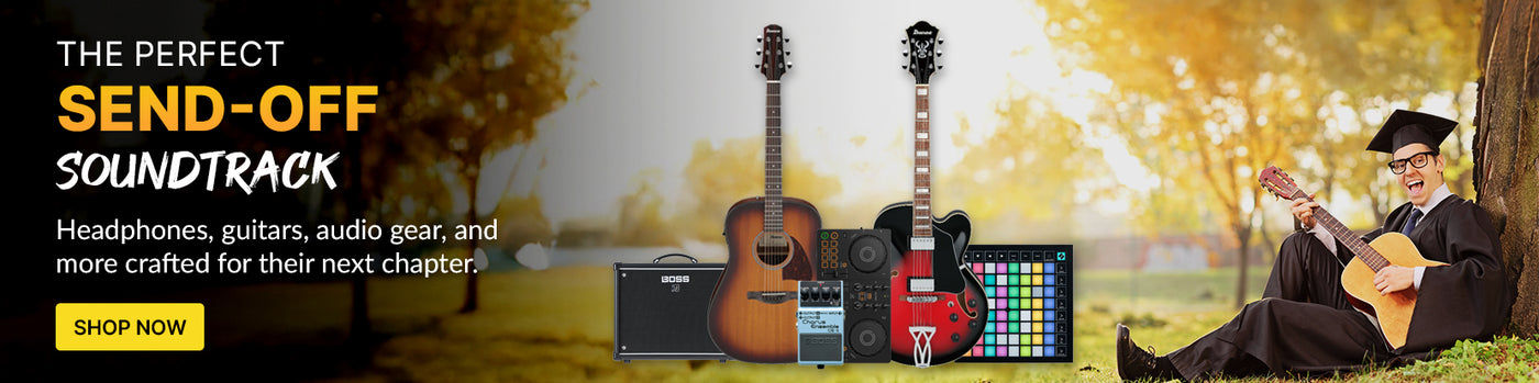 Graduate in a cap and gown playing the guitar next to an assortment of music products